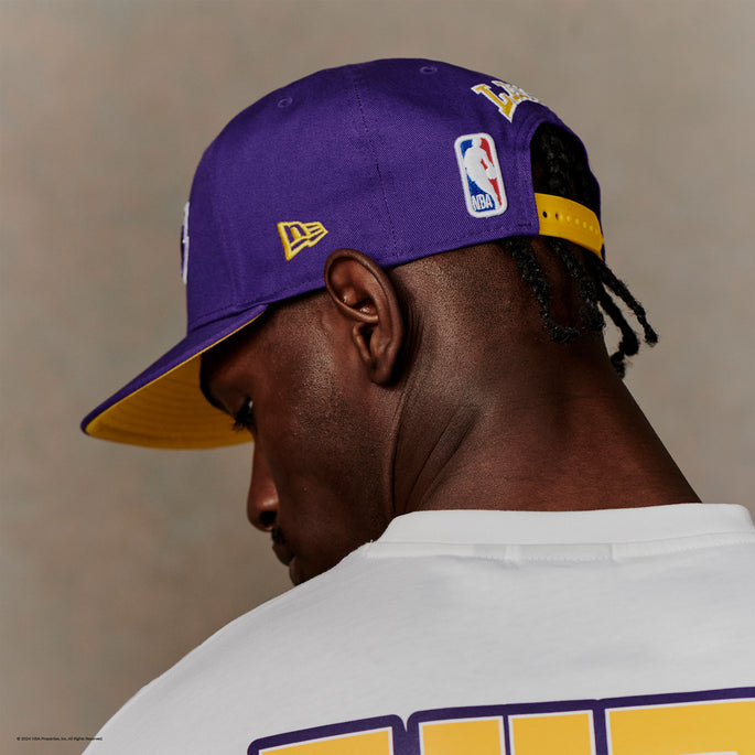 man facing away wearing a purple new era 59fifty cap