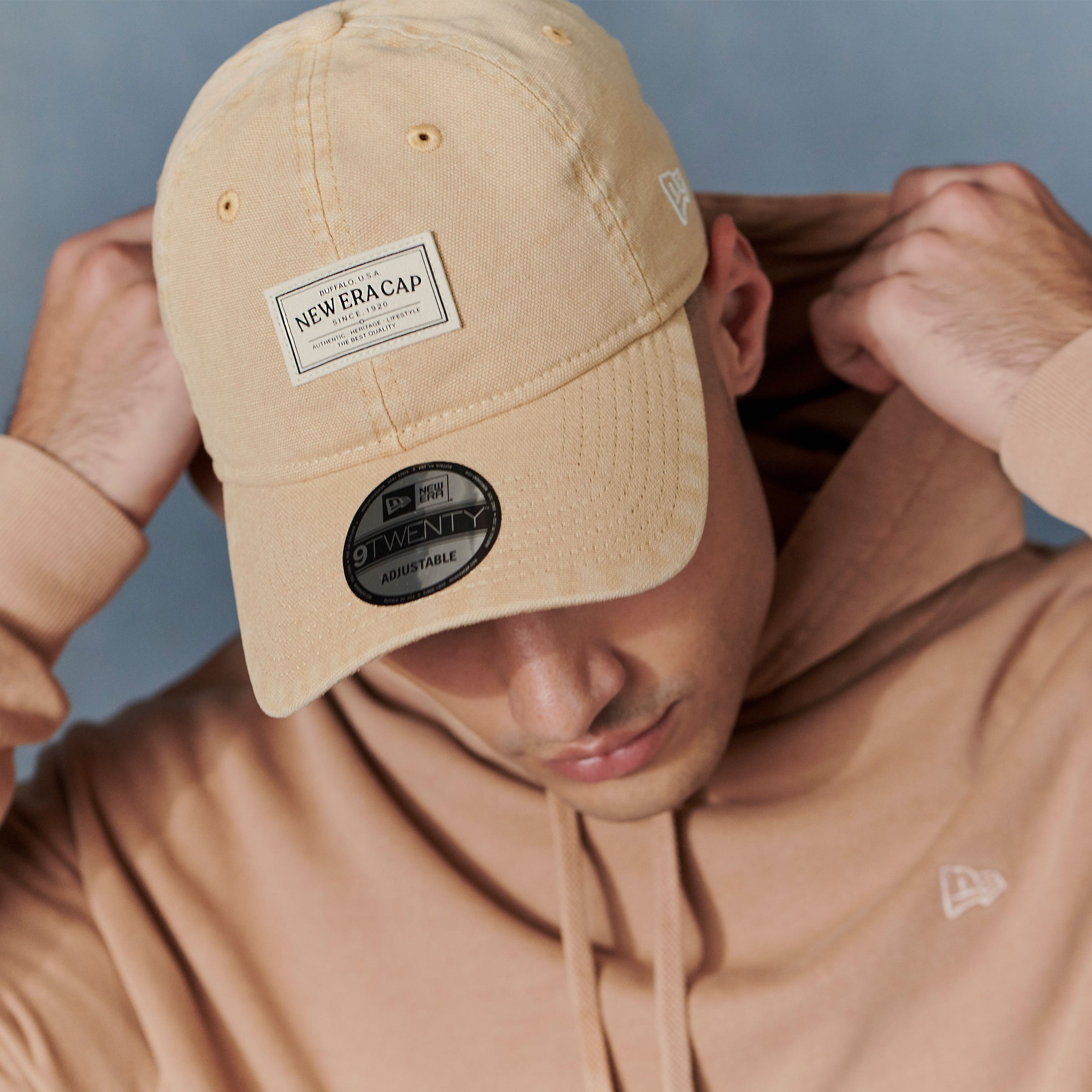 close up of male model wearing a beige new era 9twenty Cap