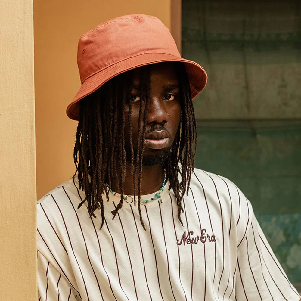 man wearing an orange new era bucket hat for accra's new wave