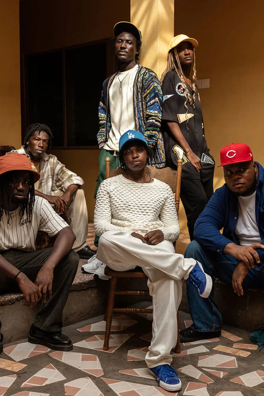 six young adults posing whilst wearing new era caps and bucket hats