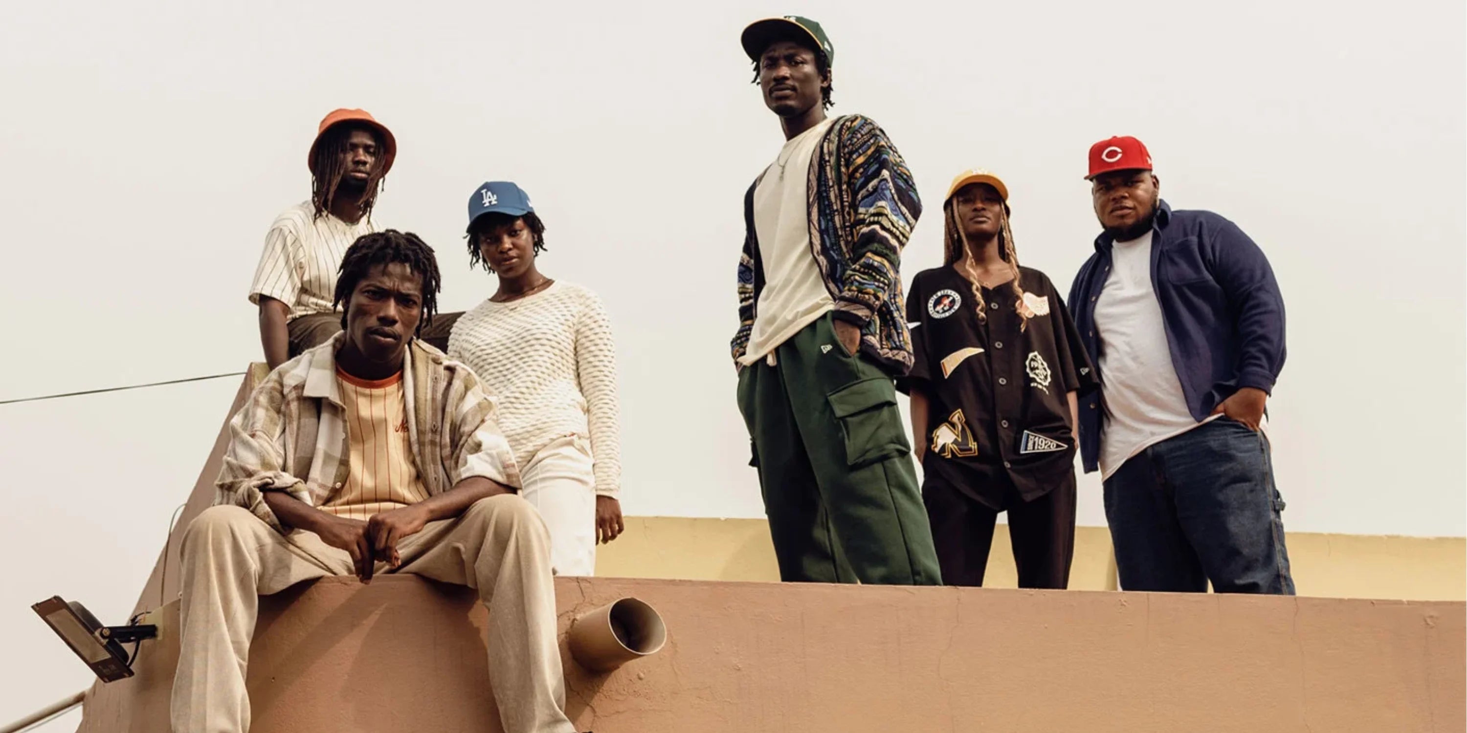 young adults posing for accra's new wave wearing new era caps and tees