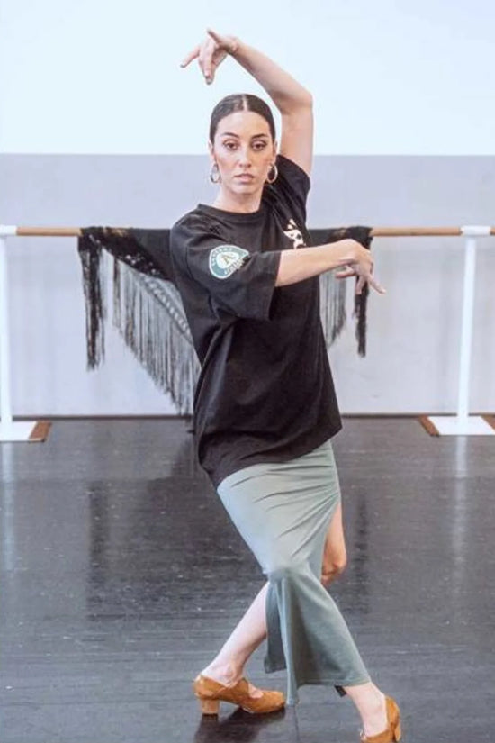 Slide 2:woman doing ballet whilst wearing a black oakland athletics t-shirt