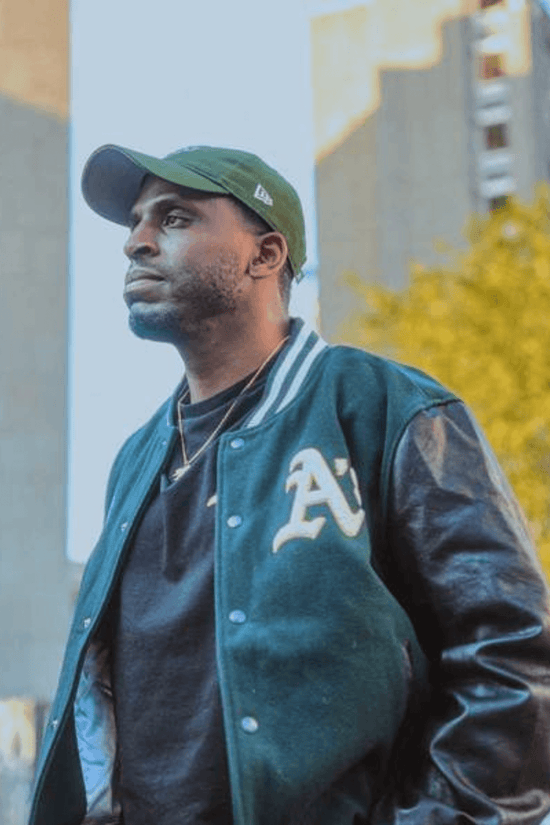 Slide 2:man wearing a green bomber jacket and cap with the oakland athletics logo