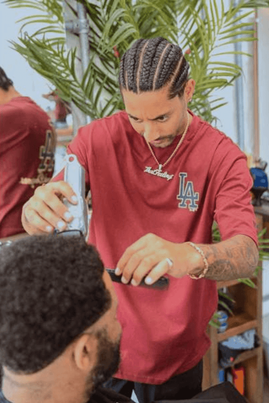 Slide 3:a barber wearing a red la dodgers t-shirt whilst cutting someone's hair