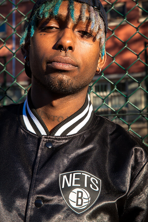 close up of male model wearing a brooklyn nets black bomber jacket