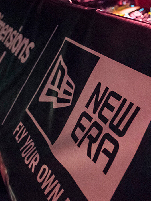 close up of dj mixset with a banner from dimensions festival with new era logo